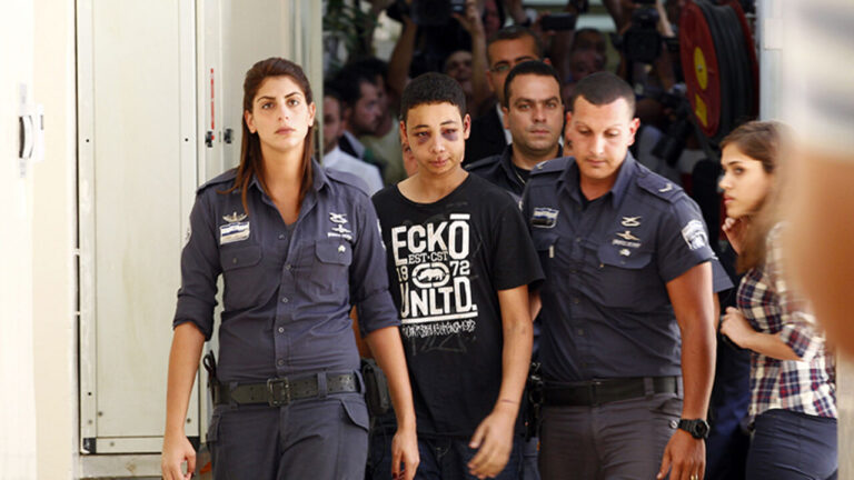 Tariq Khdeir, an American of Palestinian descent, is escorted by Israeli prison guards during an appearance at Jerusalem magistrate's court