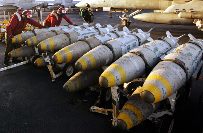 AVIATION ORDINANCEMEN ORGANISE THOUSAND POUND BOMBS ON FLIGHT DECK OFUSS KITTY HAWK IN THE GULF.